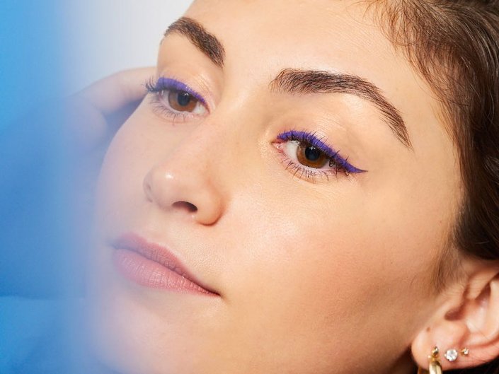 person wearing purple winged eyeliner