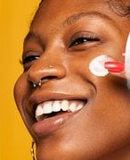 Woman applying NYX sunscreen to face