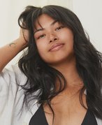 Person with wavy black hair and bangs