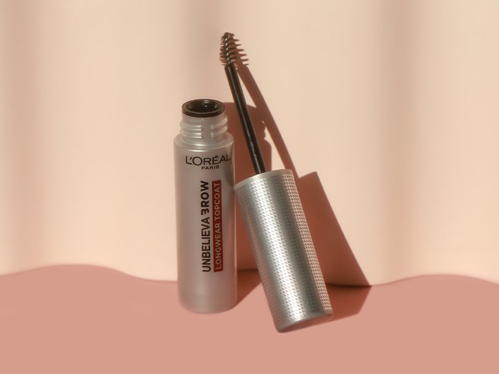 L’Oréal Paris Unbelievabrow Longwear Brow Topcoat open sitting on a blush pink surface