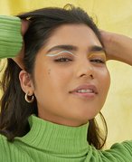 person posing with hands in hair and looking into camera