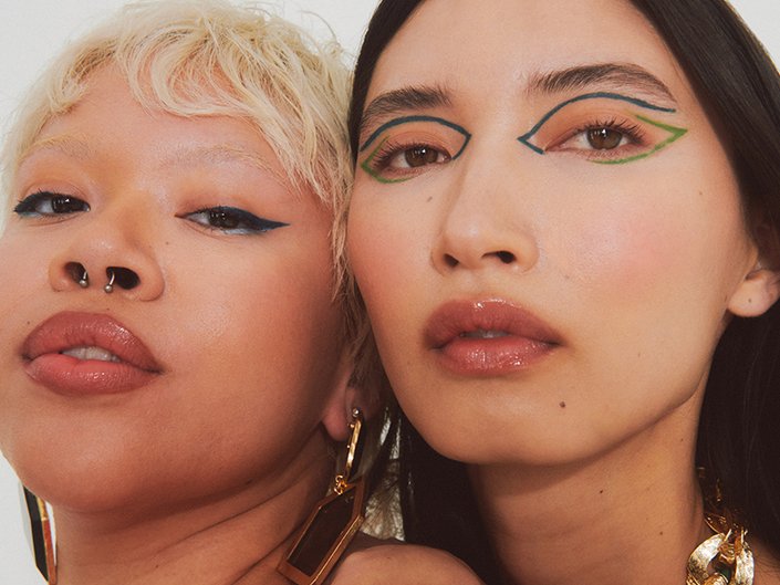 close-up photo of two models with graphic eyeliner looks
