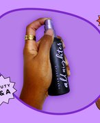 person holding the urban decay all nighter setting spray