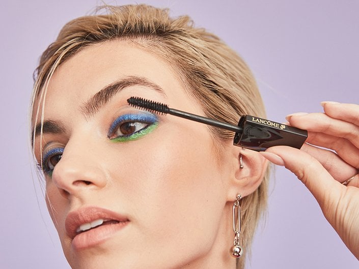 person applying mascara to their upper lashes