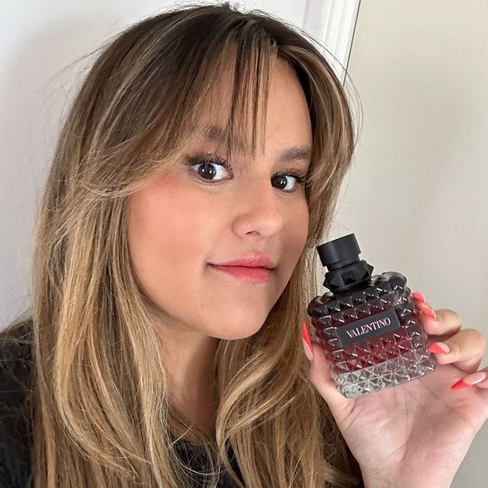 reece holding the valentino born in roma intense perfume