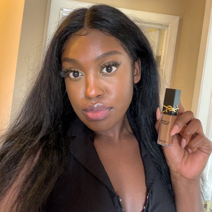 Sarah wearing and holding up the YSL Beauty All Hours Creaseless Precise Angles Concealer in DW4